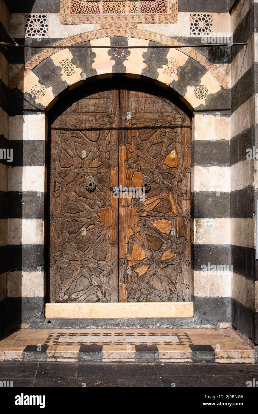 Puerta histórica de madera y arquitectura oriental en el casco antiguo de damasco, Siria Foto de stock