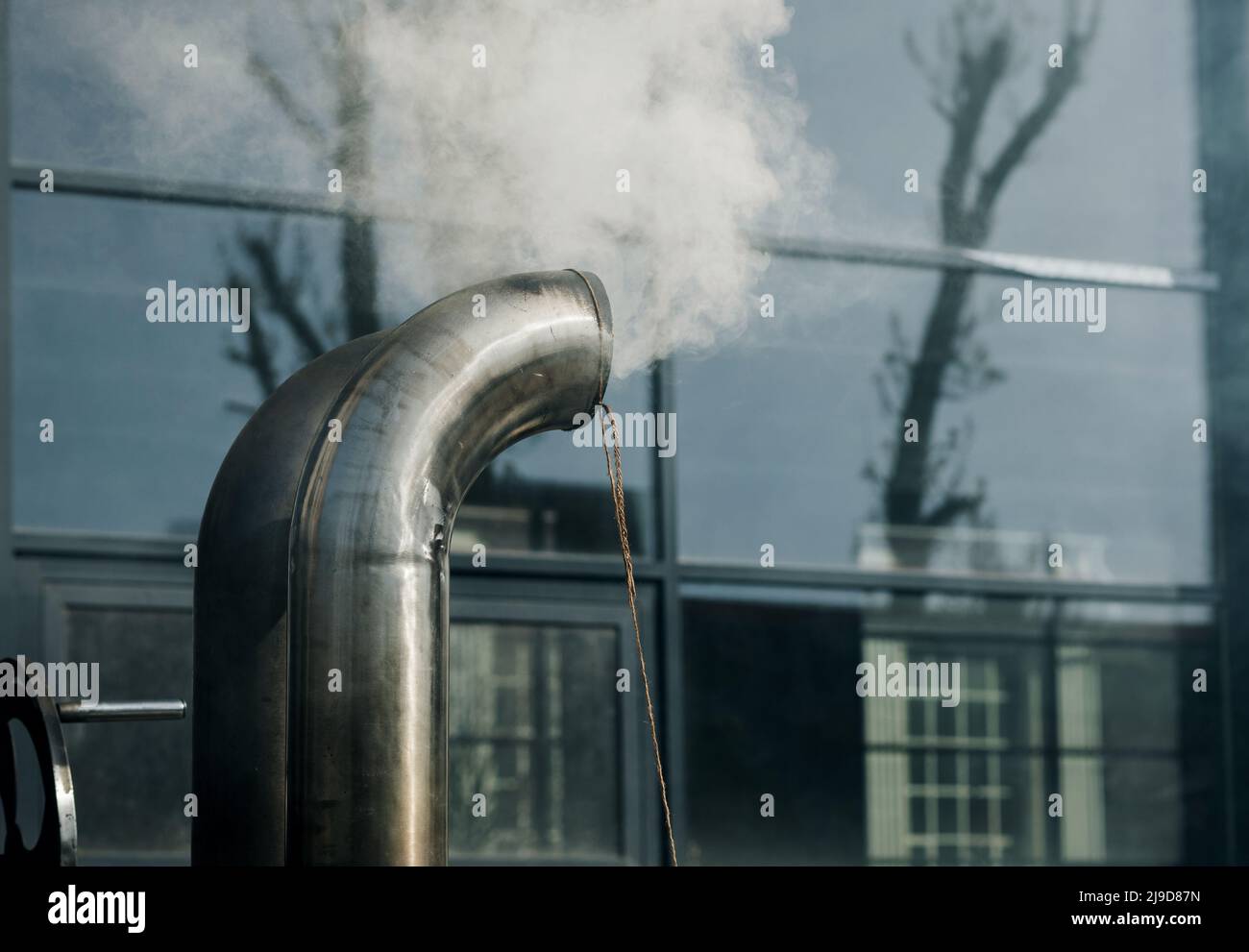 Chimenea de metal con estructura de tuberías de acero inoxidable con humo y vapor Foto de stock