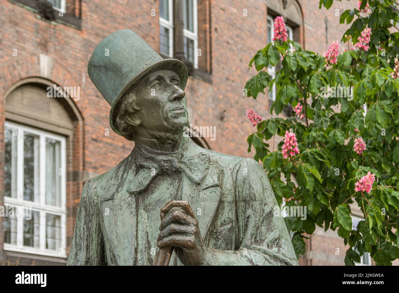 Busto de bronce del escritor danés H C Andersen, sentado frente a un edificio de ladrillo en Copenhague, Dinamarca, 21 de mayo de 2022 Foto de stock