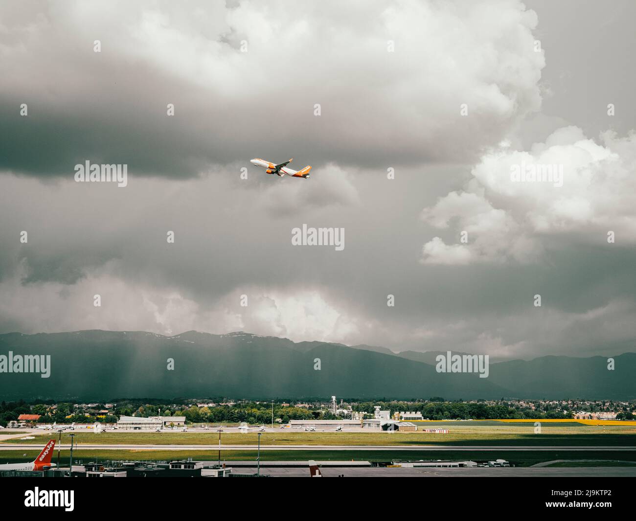 Aeropuerto de Ginebra, Suiza. Aviones y vehículos de servicio se encuentran en la pista de aterrizaje y la autopista de rodaje del aeropuerto de Ginebra en Suiza. Foto de stock
