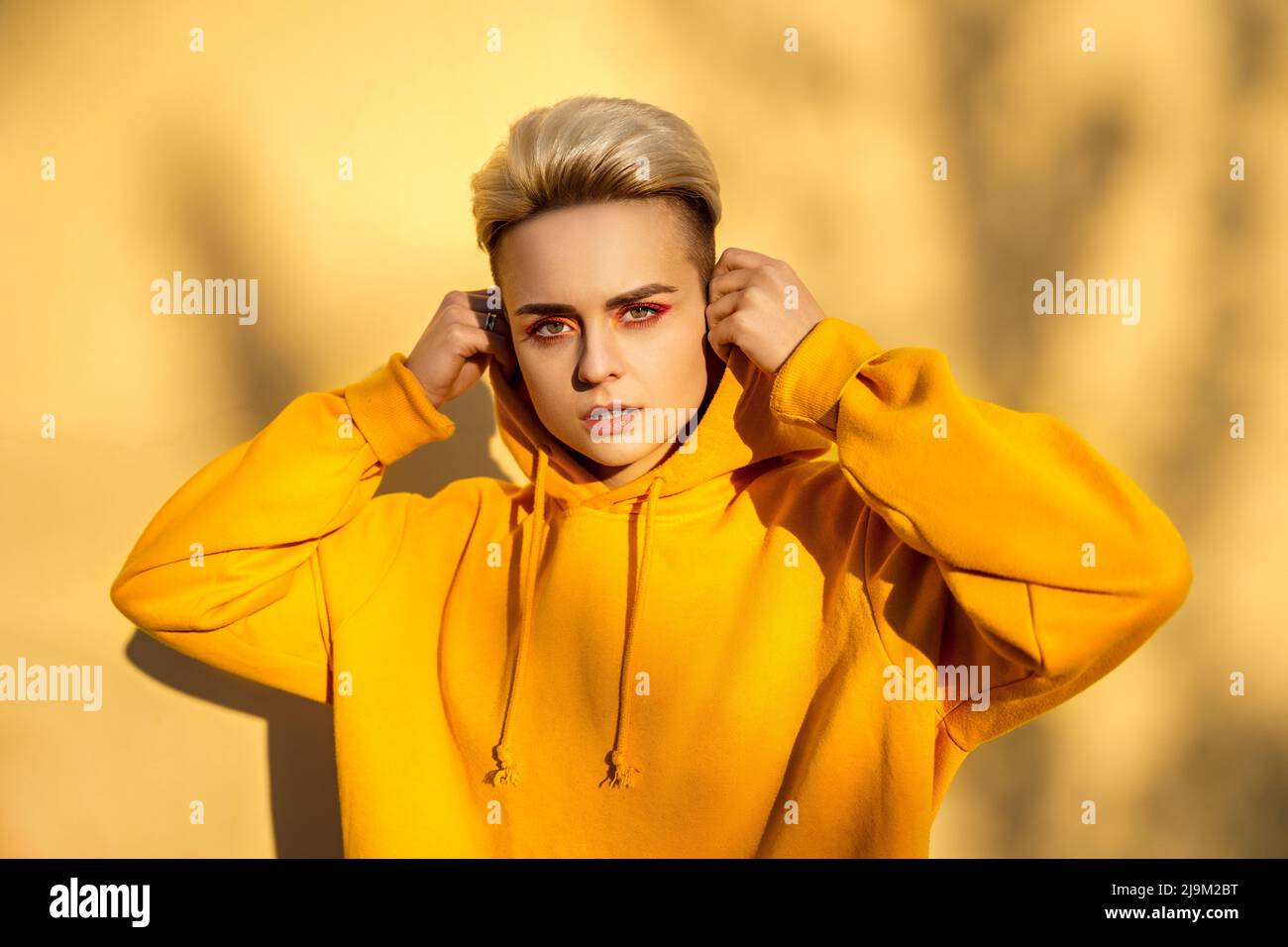 Mujer hipster joven en sudadera amarilla con capucha retrato Fotografía de  stock - Alamy
