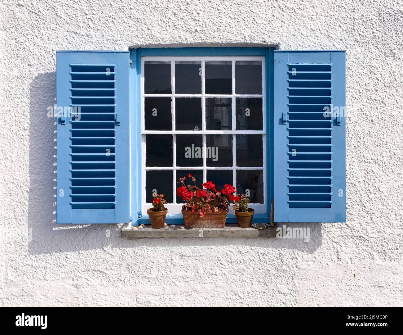 Una ventana en una casa de campo con vistas al mar en St. Mawes, Cornwall Foto de stock