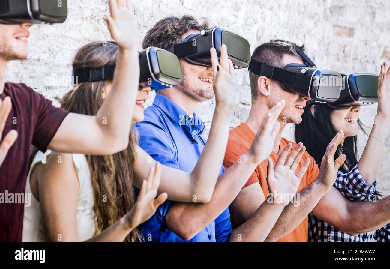 Grupo de amigos jugando en gafas vr al aire libre - realidad aumentada virtual y el concepto de tecnología portátil con jóvenes divertirse junto con la cabeza Foto de stock
