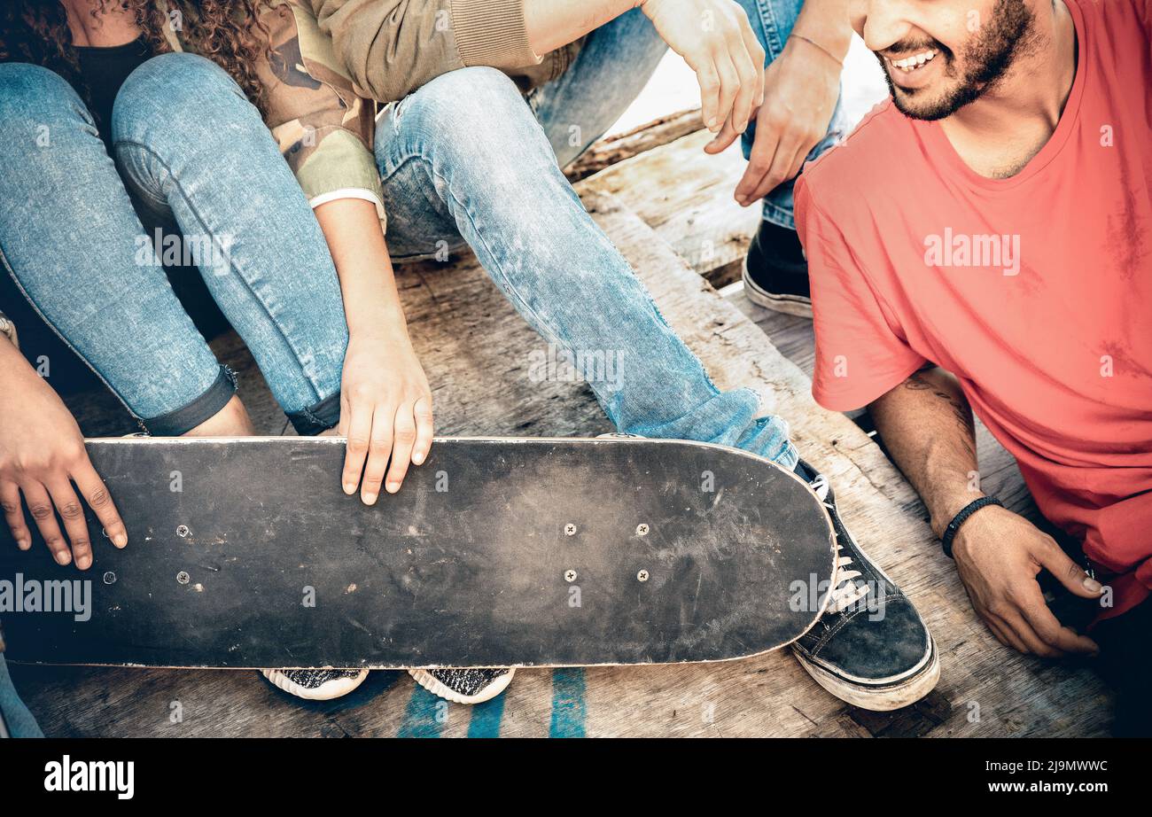 Grupo de amigos multirraciales divertirse y pasar tiempo juntos en el parque de skate board - Concepto de amistad juvenil con jóvenes que comparten skatboar Foto de stock