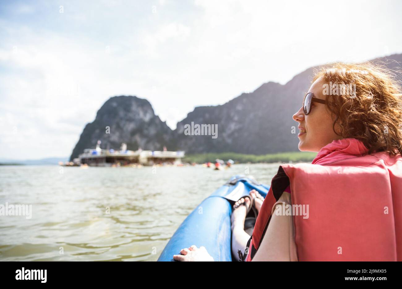 Joven mujer viajera con chaleco salvavidas al atardecer en kayak isla hopping - Wanderlust concepto de viaje con aventura chica turista wanderer en el club Foto de stock