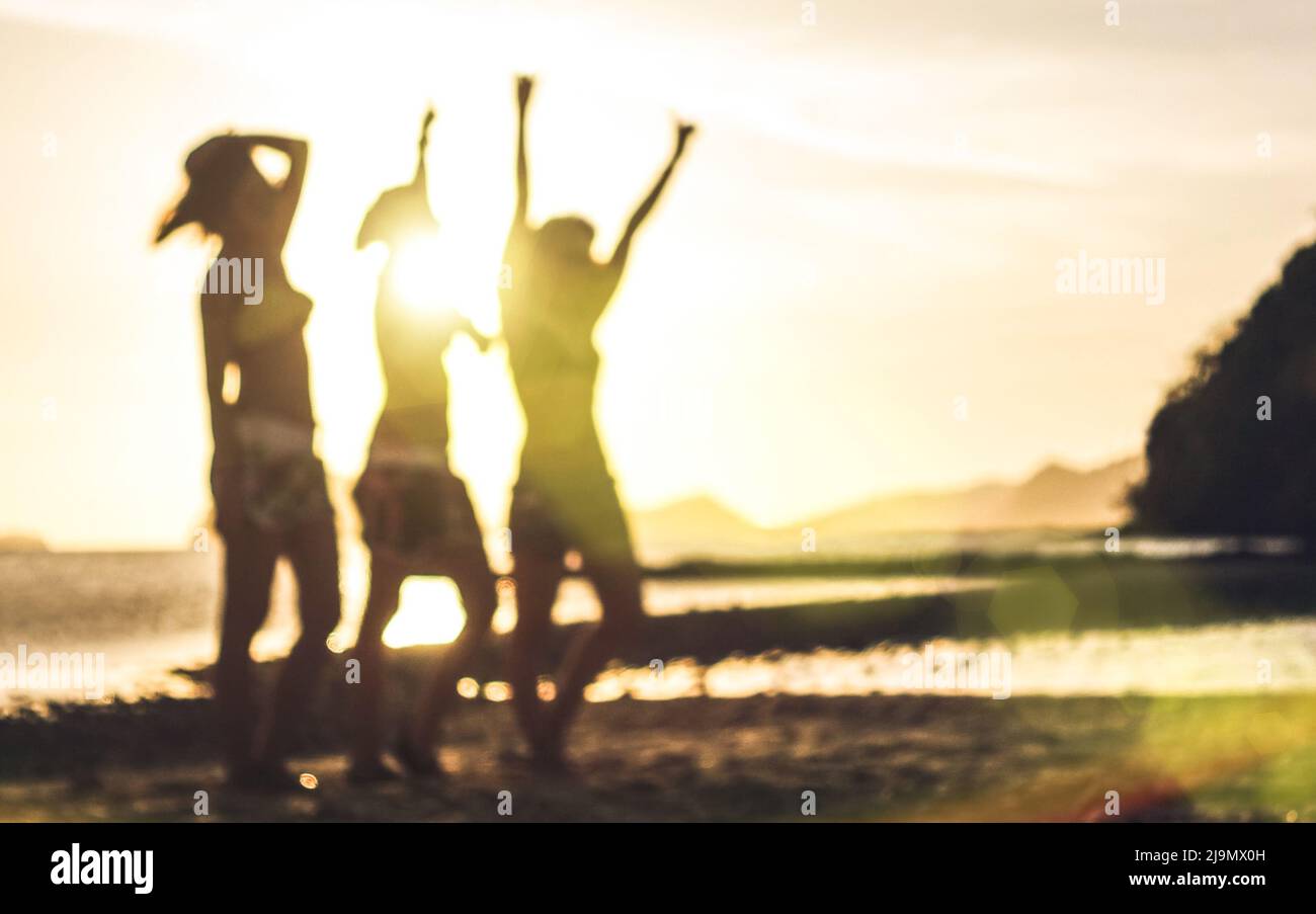 Silueta desfocada borrosa de las mujeres que viajan al atardecer - Concepto de la lujuria de viajes con jóvenes amigas que se divertían y bailaban en la playa por El N Foto de stock