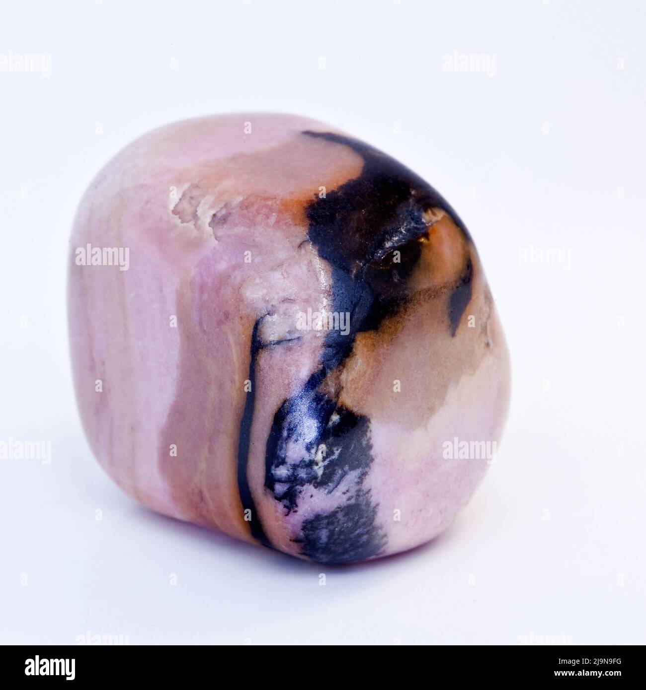 Macro primer plano fotografía en color de una ' Rhodonita ' pulida Una piedra preciosa semi-cristal utilizada en la terapia curativa del cristal Foto de stock