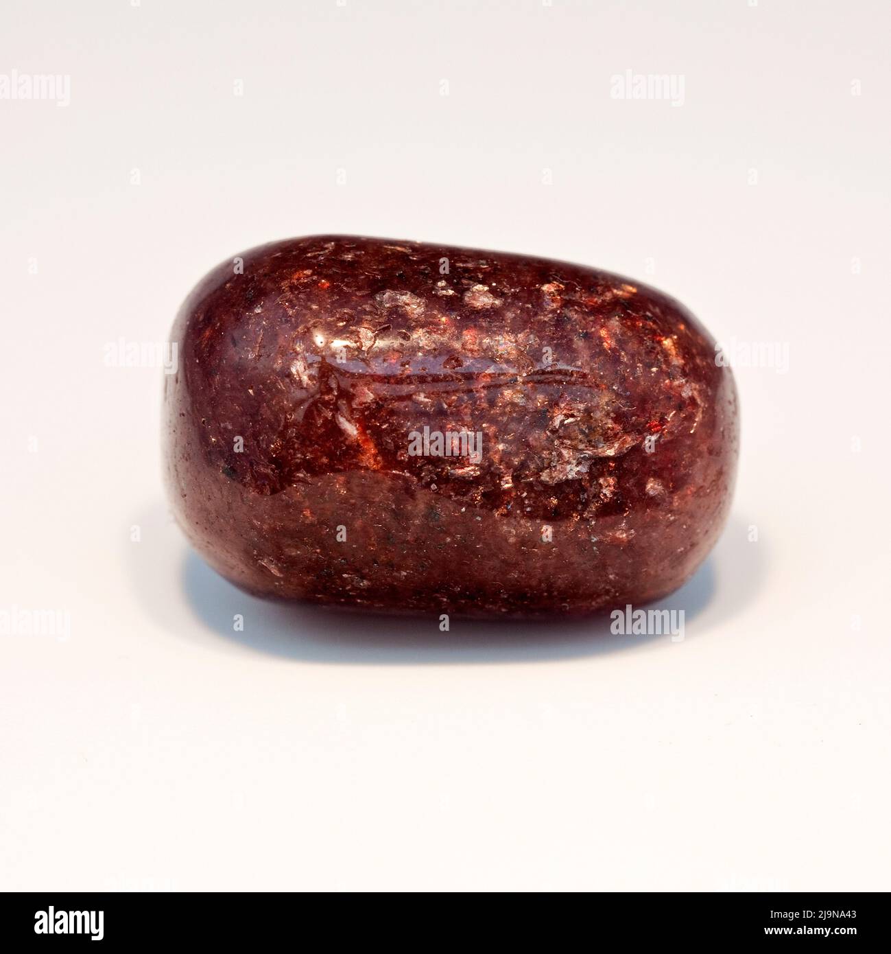 Macro fotografió una fotografía en color de cerca de una pulida 'Mica moscovita roja', una piedra curativa semipreciosa de cristal Foto de stock