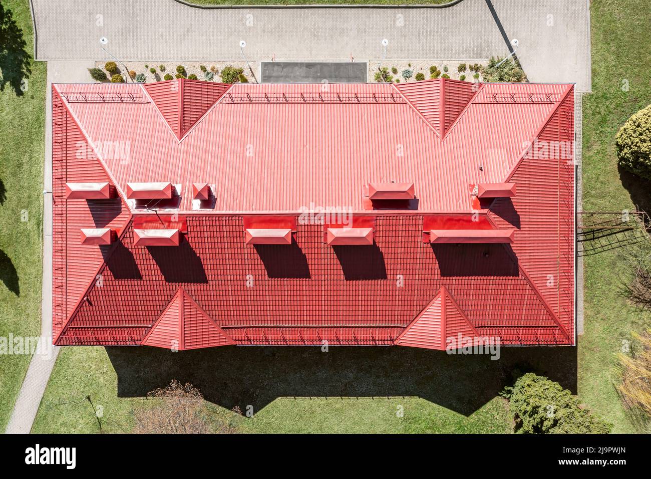vista aérea de la casa con techo inclinado de metal corrugado rojo, chimeneas y tubos de ventilación Foto de stock