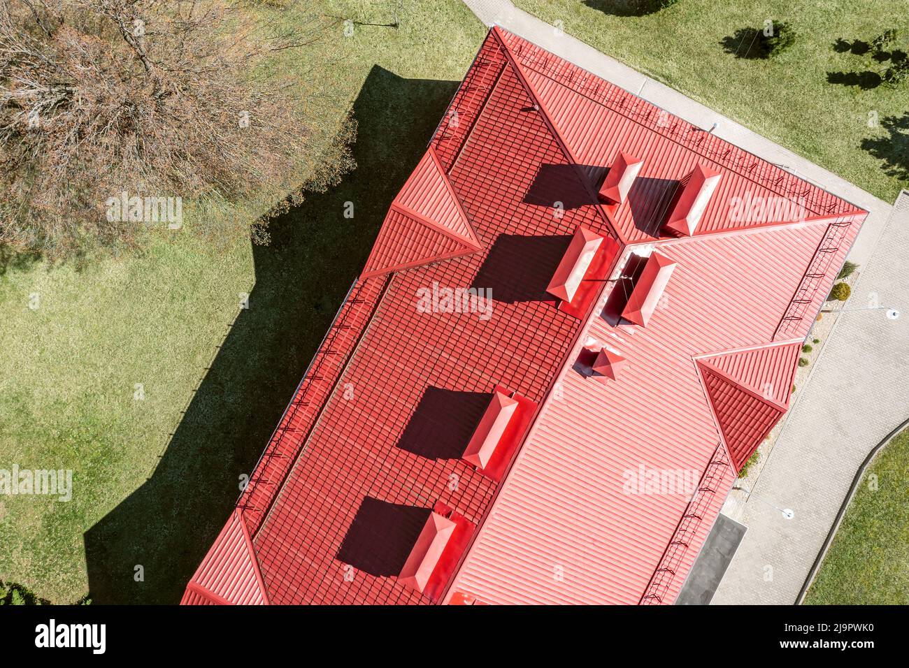 techo de metal rojo de la casa con tubos de ventilación y ventanas dormer. drone fotografía. Foto de stock