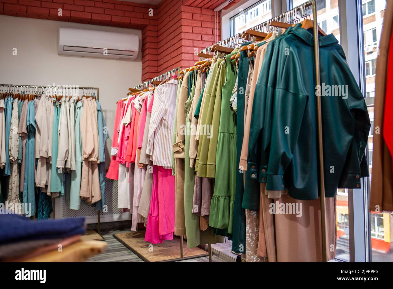 Vistosos vestidos para mujer en perchas en una tienda. Moda y concepto de  compras. Tienda de ropa para mujer Fotografía de stock - Alamy