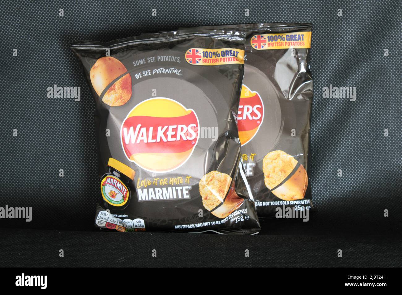 Paquete de patatas fritas Walkers, sabor Marmite crujiente sobre un fondo negro con espacio de copia. Lancashire, Reino Unido Foto de stock