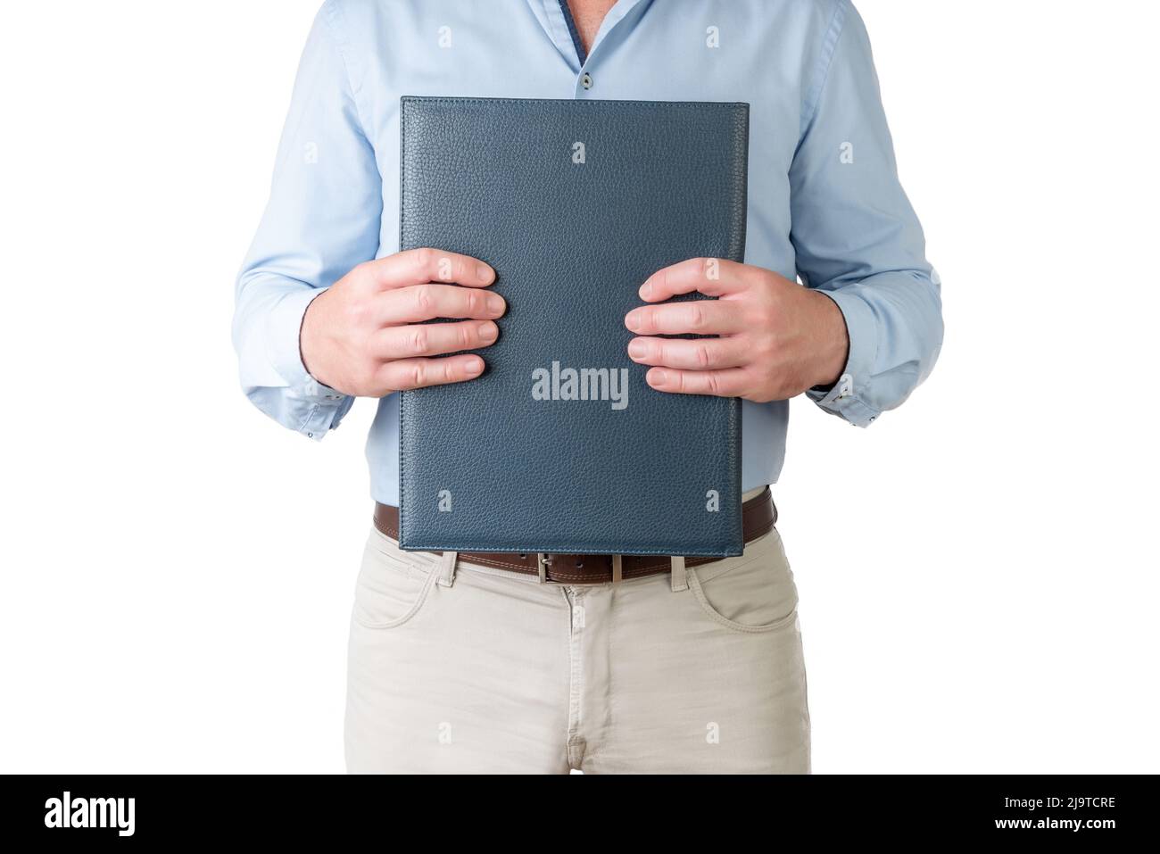 vender vacante sentido Hombre con camisa azul claro y pantalones beige sosteniendo una carpeta  cerrada con ambas manos sobre un fondo blanco Fotografía de stock - Alamy