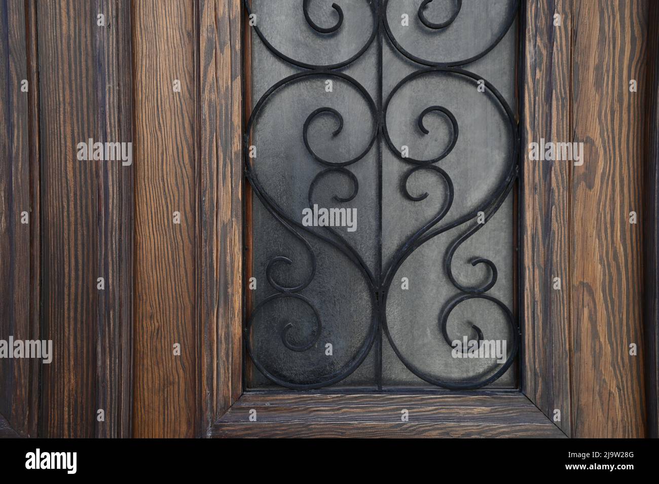 Puerta de entrada de madera marrón antigua con rejillas de hierro forjado  artesanales Fotografía de stock - Alamy