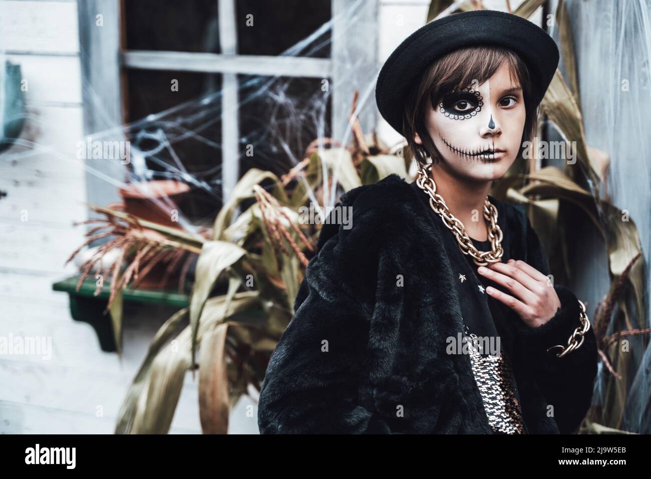 Hermosa niña de miedo celebrando halloween. Terrorífico maquillaje negro, blanco y medio rostro, traje de bruja, imagen con estilo. Horror, diversión en los niños Fotografía de stock - Alamy Hermosa niña de miedo celebrando halloween. Terrorífico maquillaje negro, blanco y medio rostro, traje de bruja, imagen con estilo. Horror, diversión en los niños Fotografía de stock - Alamy