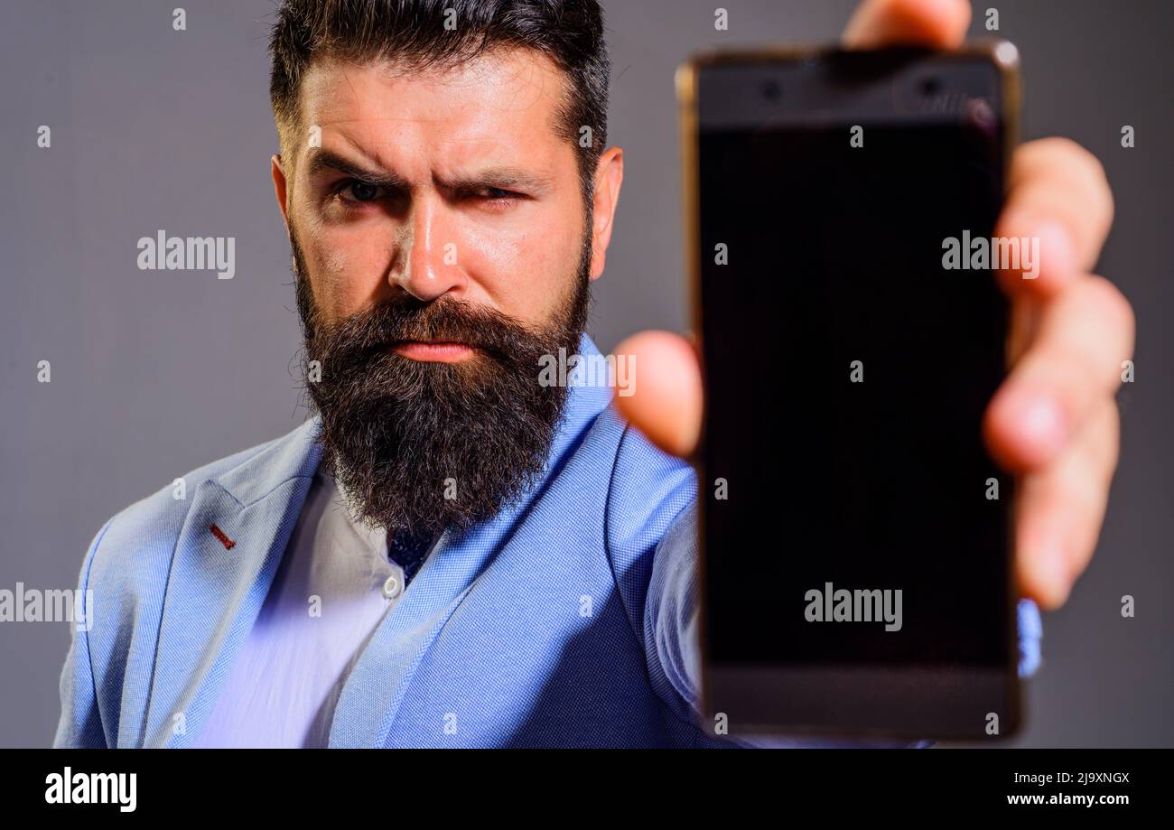 Hombre de negocios barbudo con smartphone o teléfono móvil. Negocios, comunicación, internet, tecnología. Foto de stock