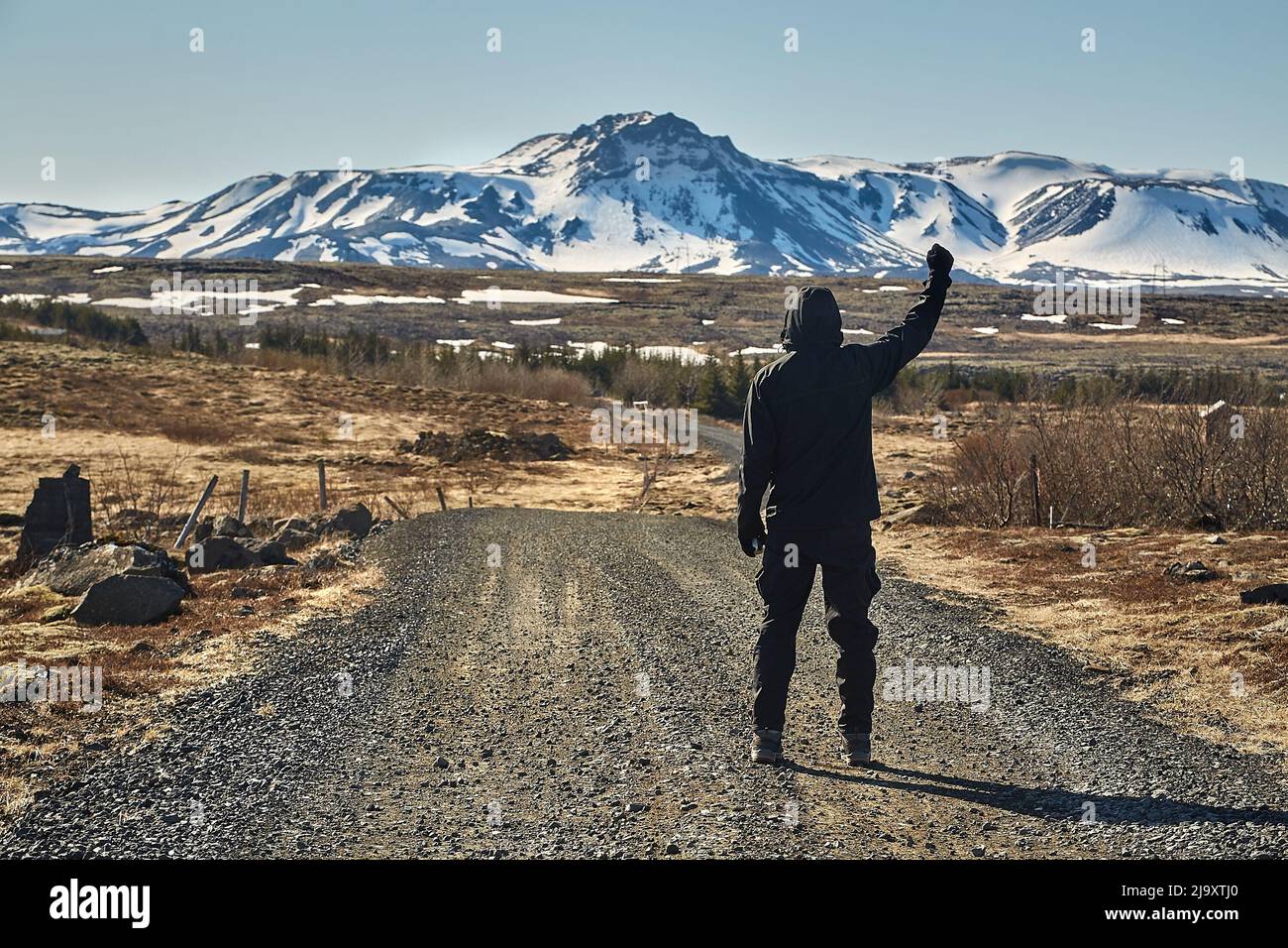 Hombre caminando por carretera de grava en Islandia Foto de stock
