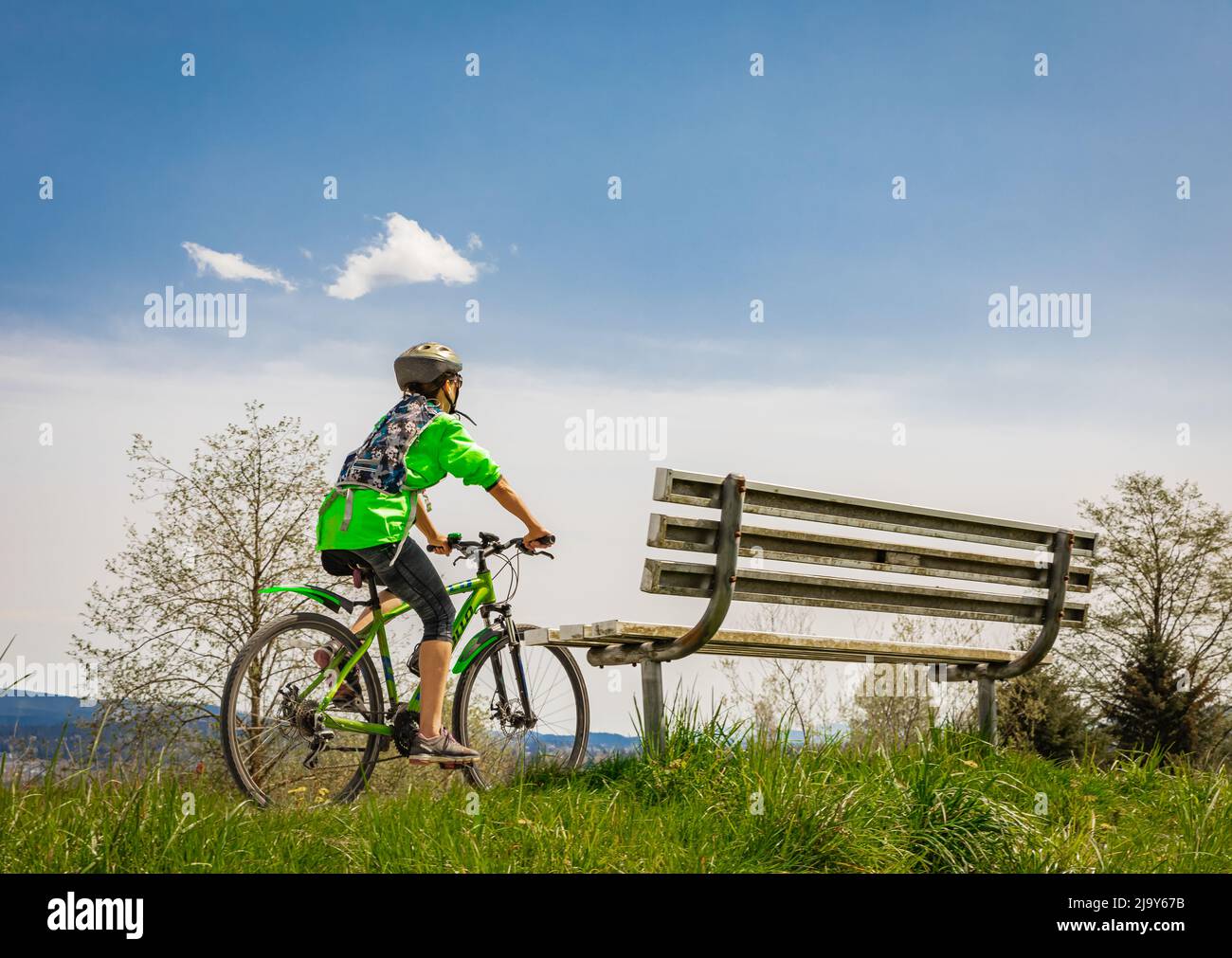 Joven mujer activa montando en bicicleta en un parque en un día soleado. Personas activas. Al aire libre. Foto de calle, enfoque selectivo, espacio de copia para texto Foto de stock