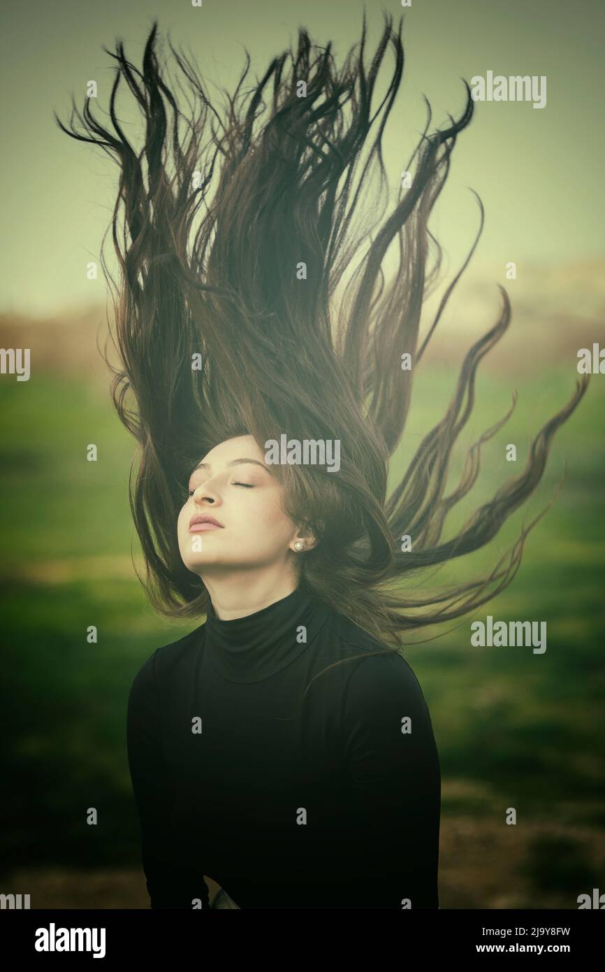 Hermosa mujer joven sacudiendo el cabello Foto de stock