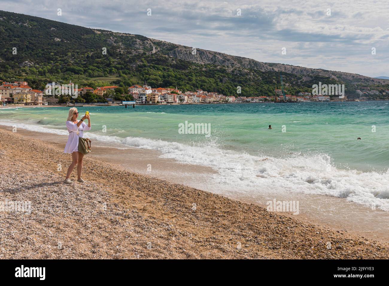 Mujer haciendo selfie en la playa de Baska Foto de stock