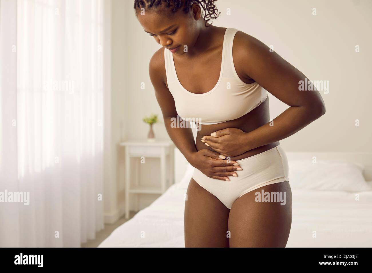 La mujer que tiene dolor de estómago, diarrea o cólicos menstruales siente dolor en su vientre Foto de stock