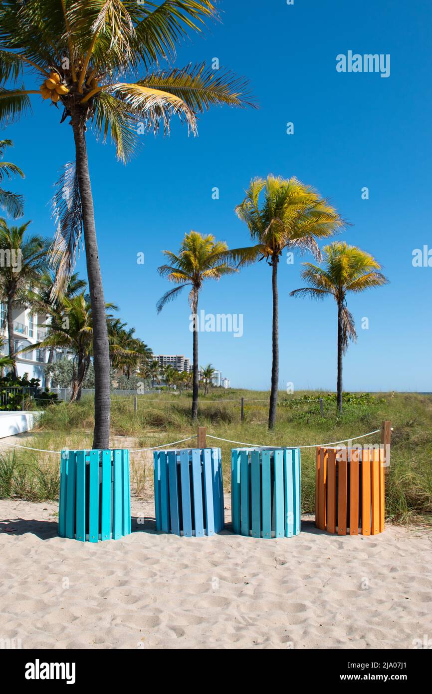 Botes de basura coloridos en la playa. Foto de stock