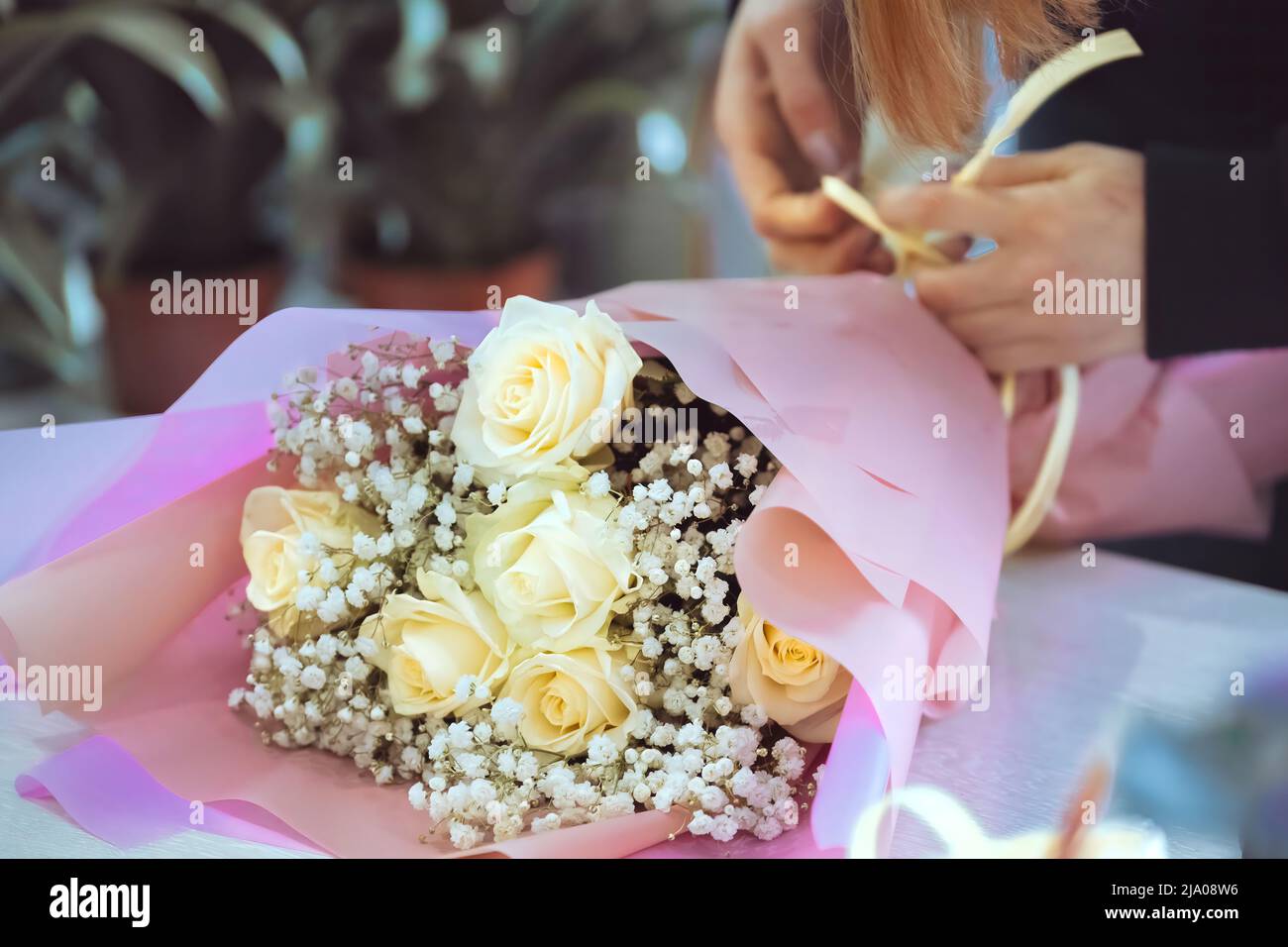 Floristería en el trabajo, mujer haciendo ramo de moda de flores de rosas Foto de stock