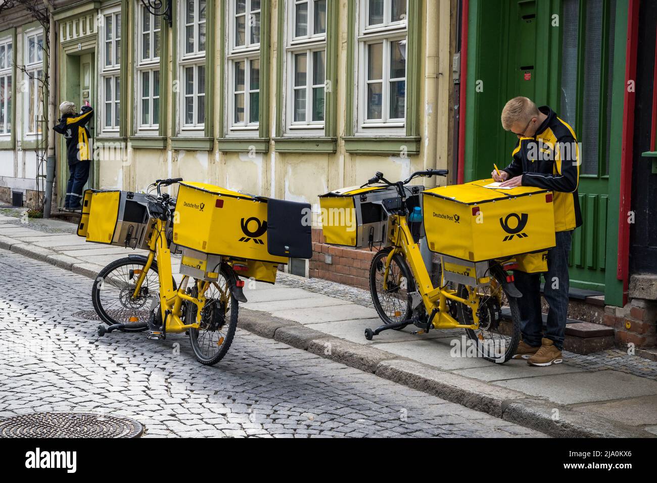 El cartero alemán del Deutsche Post entrega de correo con una bicicleta eléctrica. Werningrode, Alemania - 26 de abril de 2018 Foto de stock