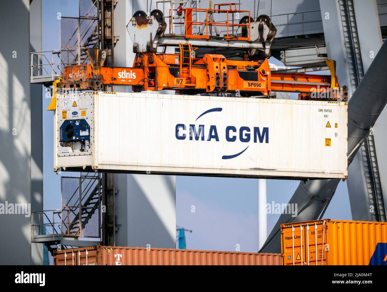 Operario de grúa que descarga un contenedor refrigerado de un buque de carga en el Puerto de Rotterdam. Países Bajos - 16 de marzo de 2016 Foto de stock