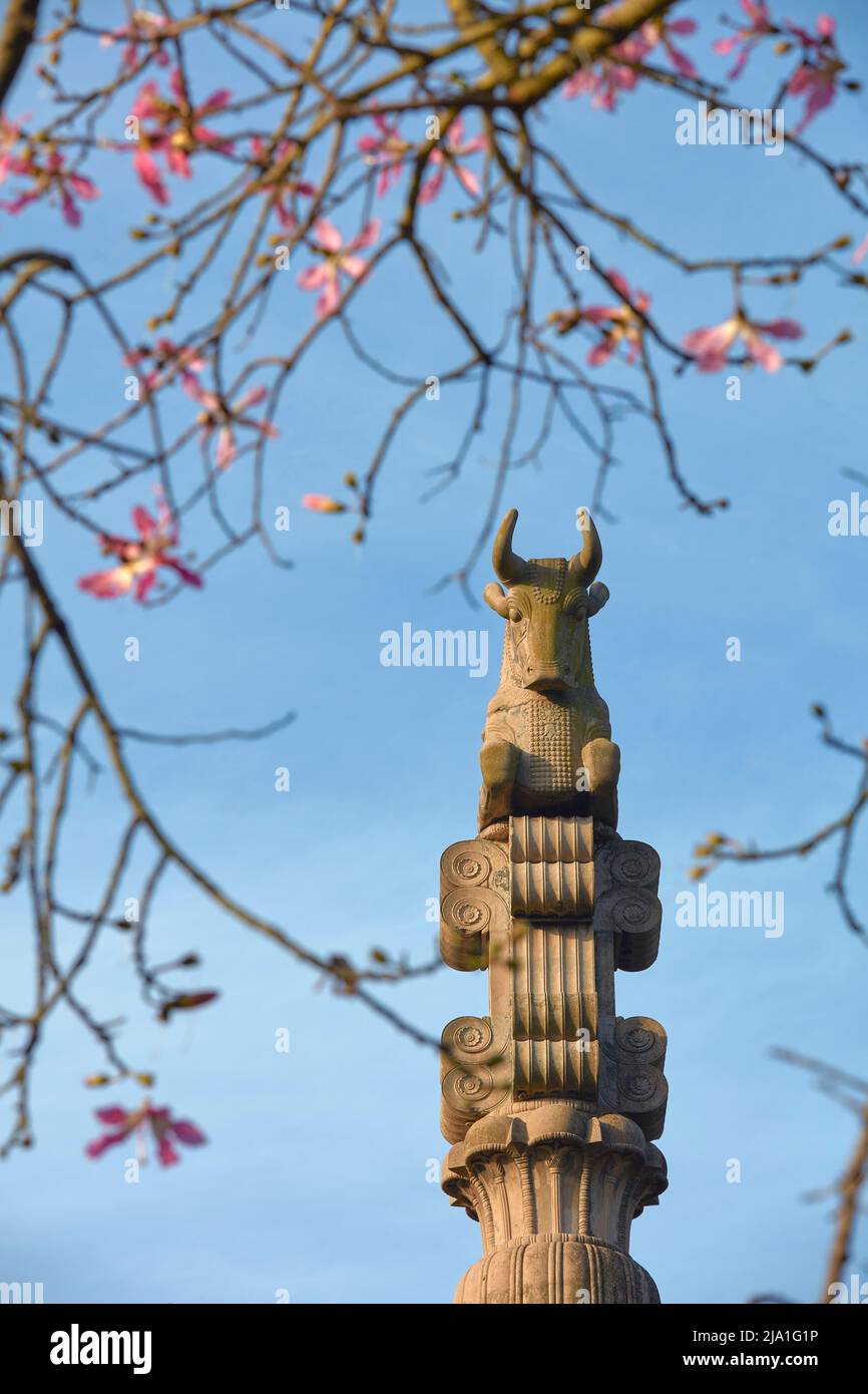 La escultura “La columna del templo Persa” entre flores de seda, jardines de Palermo, Buenos Aires, Argentina. Foto de stock