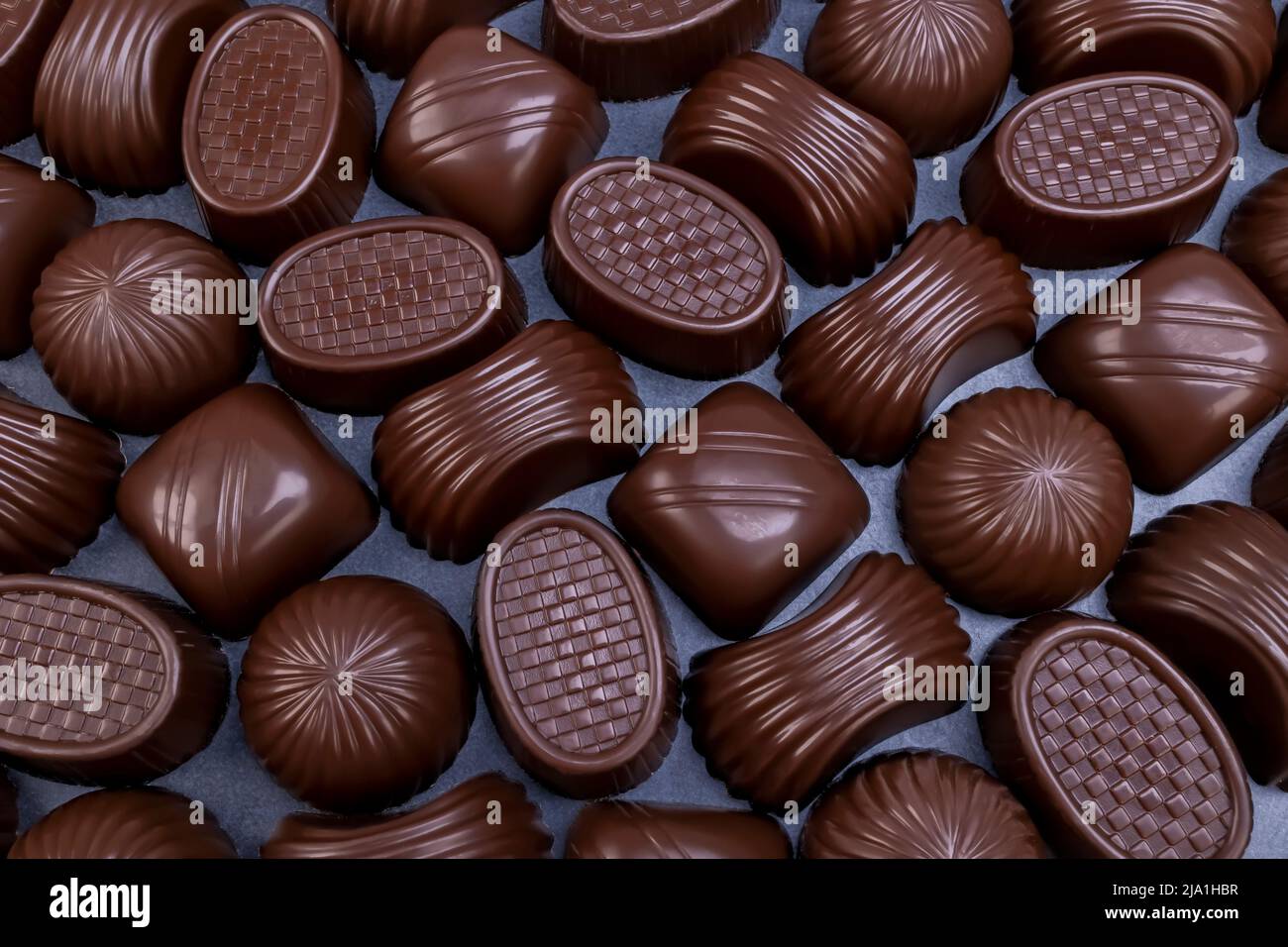Pralinés variados de chocolate negro sobre fondo negro. Chocolate amoroso y dulces concepto Foto de stock