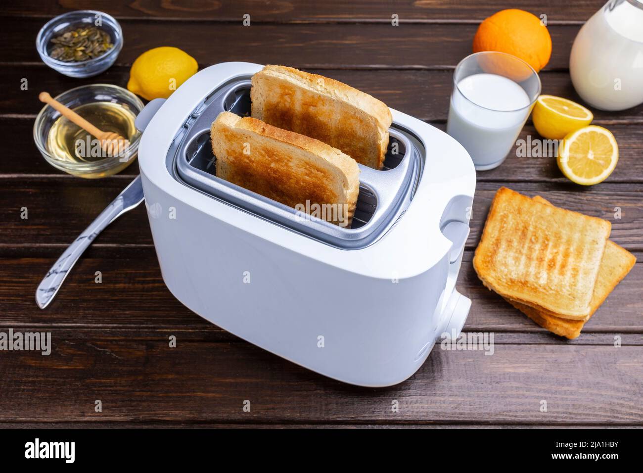 Rodajas de pan tostado del tostador. Alimentos saludables para el desayuno y concepto de tecnología de calefacción. Foto de stock