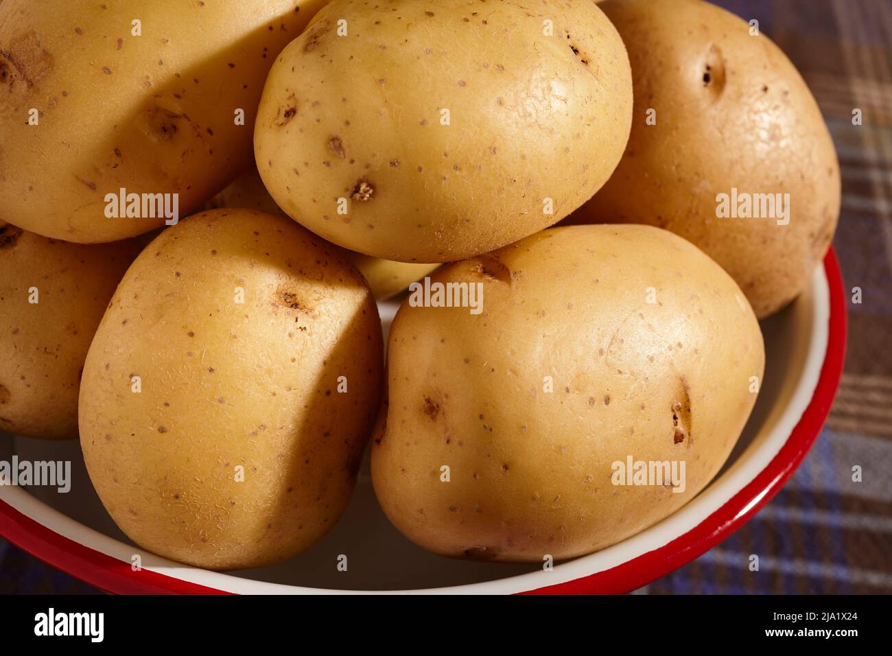 Crudo, entero, oro yukón, patatas en un tazón Foto de stock