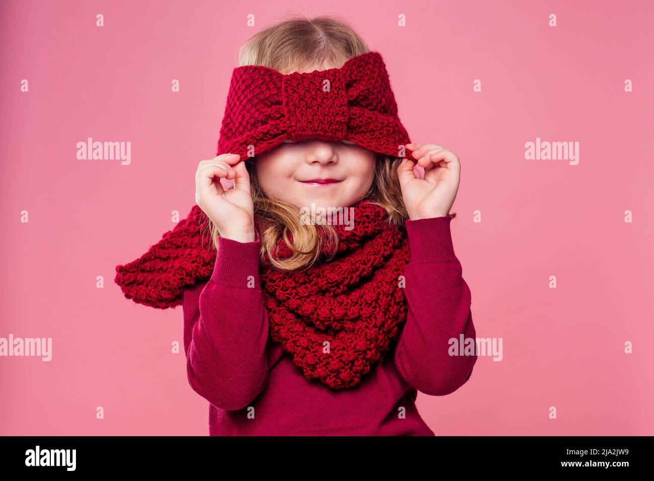 Niña vestidos vivamente en una sudadera rosa, sombrero, guantes, bufanda y  botas peludos, jugando en la nieve Fotografía de stock - Alamy