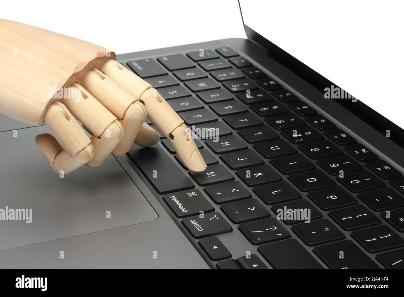 Mano de madera pulsando el botón del teclado del portátil, sobre fondo blanco primer plano Foto de stock
