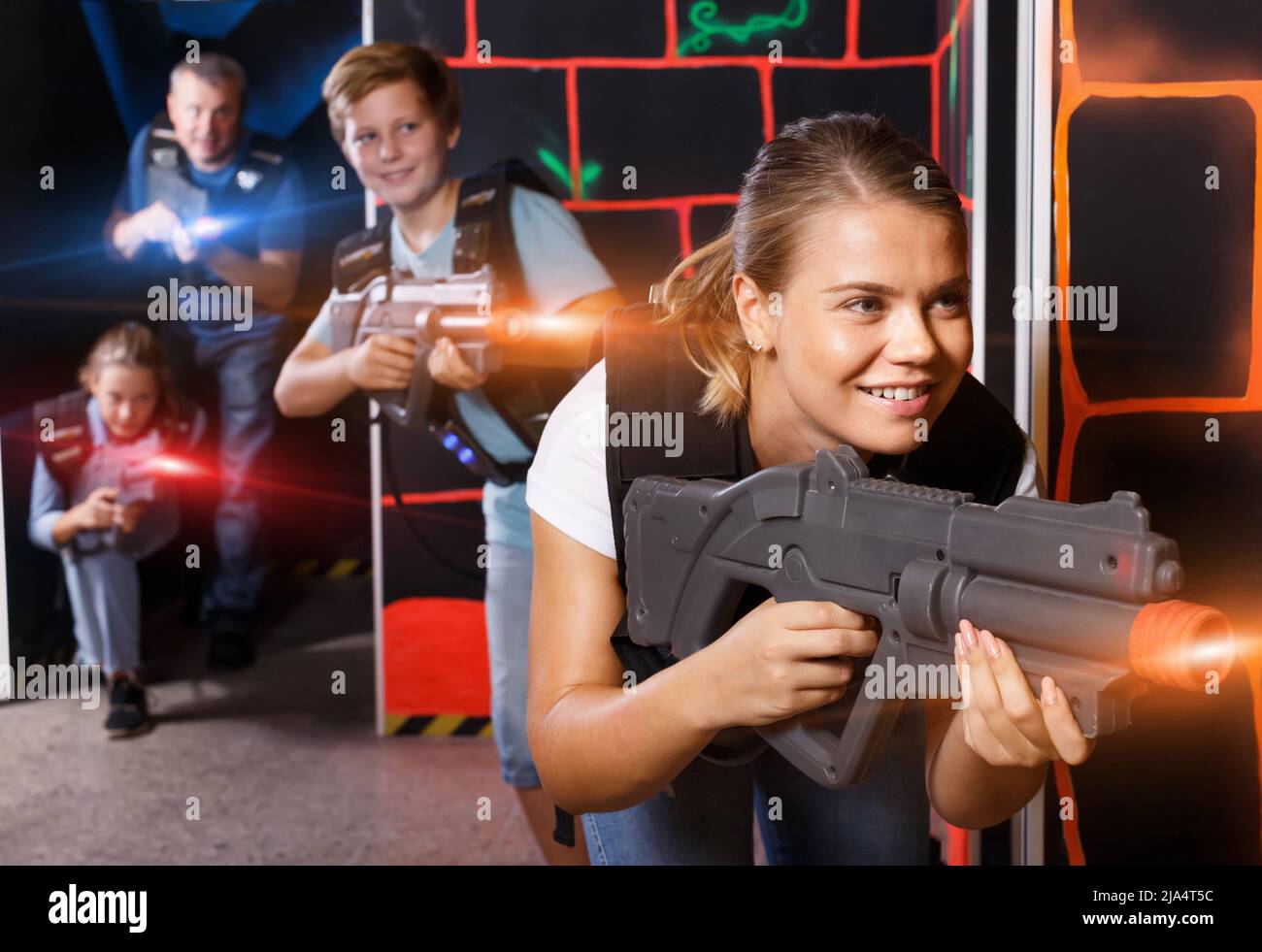 Feliz niña joven con arma láser durante juego de etiqueta láser con pla  Fotografía de stock - Alamy