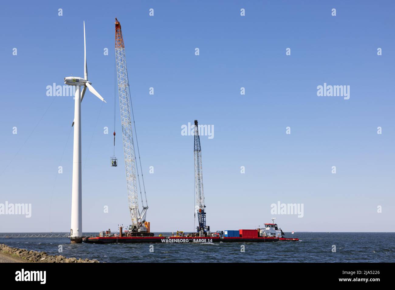 Lelystad, Países Bajos - 22 de abril de 2022: Grúa de los trabajadores de elevación de buques en góndola para demolición de parques eólicos marinos Foto de stock