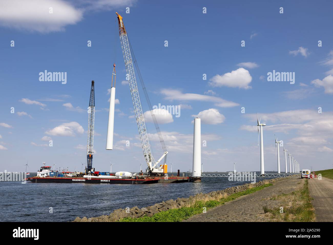 Lelystad, Países Bajos - 22 de abril de 2022: Grúa y buque de suministro ocupado con la demolición de la antigua turbina eólica marina Foto de stock