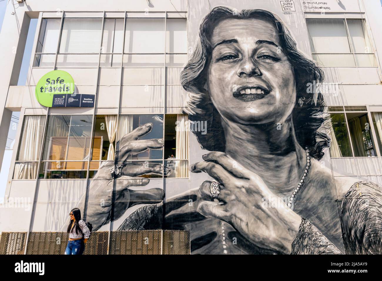 Una mujer posa frente a un mural de calle, Distrito Barranco, Lima, Perú. Foto de stock