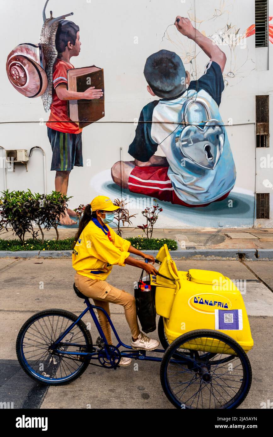 Un vendedor de helados pasa por un Colorful Wall Mural en el Distrito de Barranco, Lima, Perú. Foto de stock