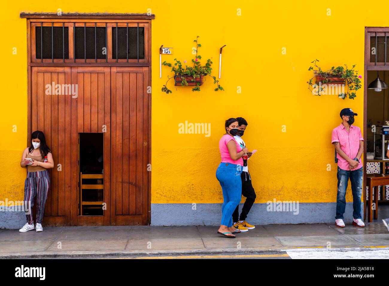 Gente peruana esperando fuera de un Centro Médico, Distrito Barranco, Lima, Perú. Foto de stock