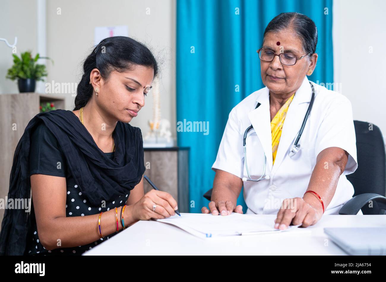 mujer paciente firmar documentos delante del médico en el hospital - concepto de seguro de salud, y consentimiento para la póliza Foto de stock