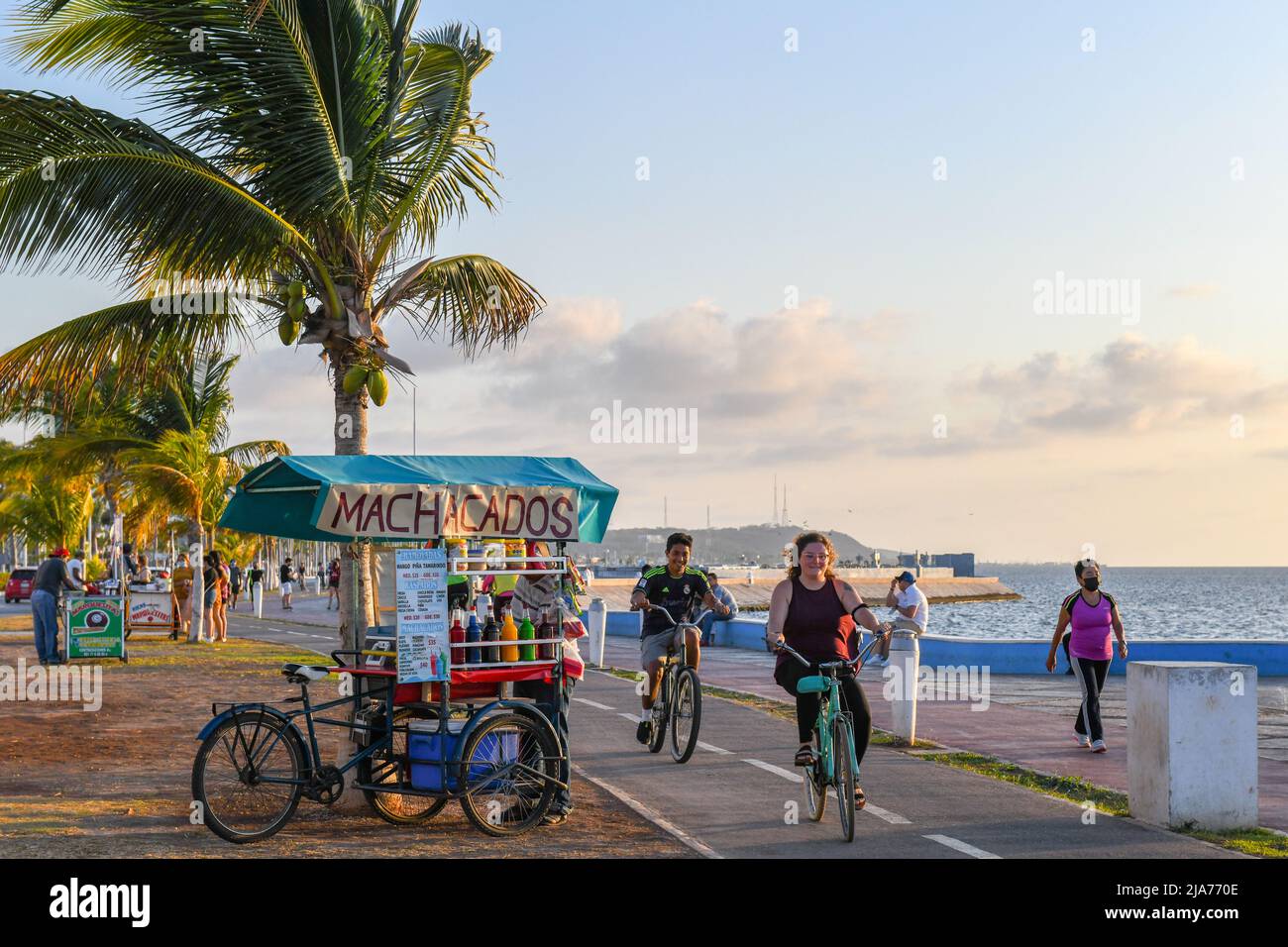 Gente en bicicleta por el sendero de bicicletas en el paseo marítimo en Campeche México Foto de stock