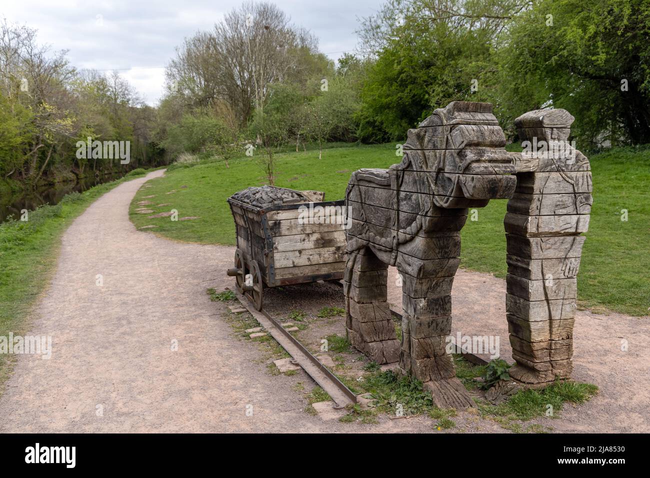 Grupo de esculturas de madera de Robert Jakes en Watton Wharf, junto al canal Monmouthshire y Brecon, marcando la línea del antiguo tranvía tirado por caballos Foto de stock
