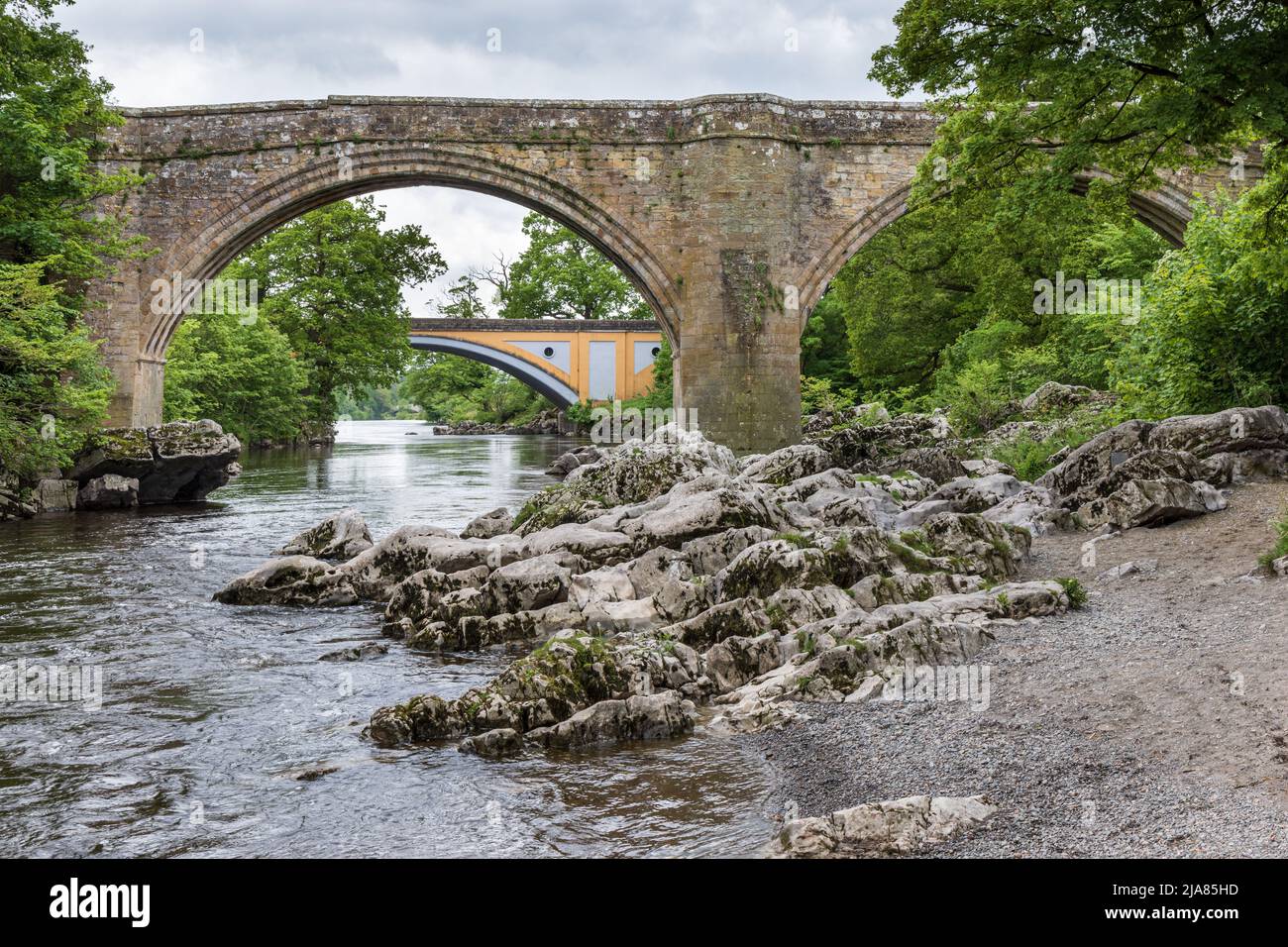 El famoso Devil's Bridge, y el puente principal de la carretera A65 más allá, que cruza el río Lune en Kirkby Lonsdale, Cumbria, Inglaterra, Reino Unido Foto de stock