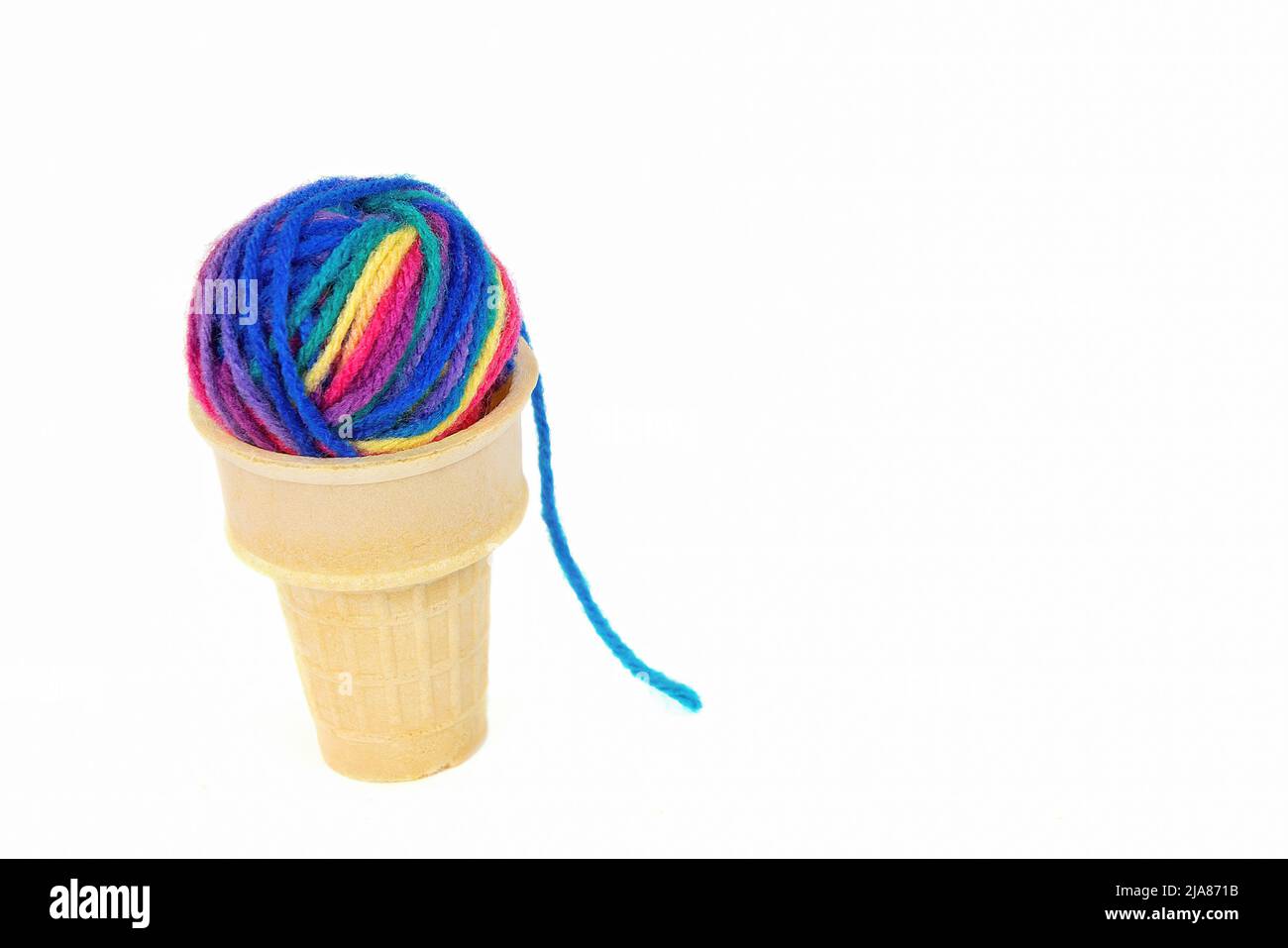 Bola de hilo de colores en cono helado aislado sobre fondo blanco Foto de stock
