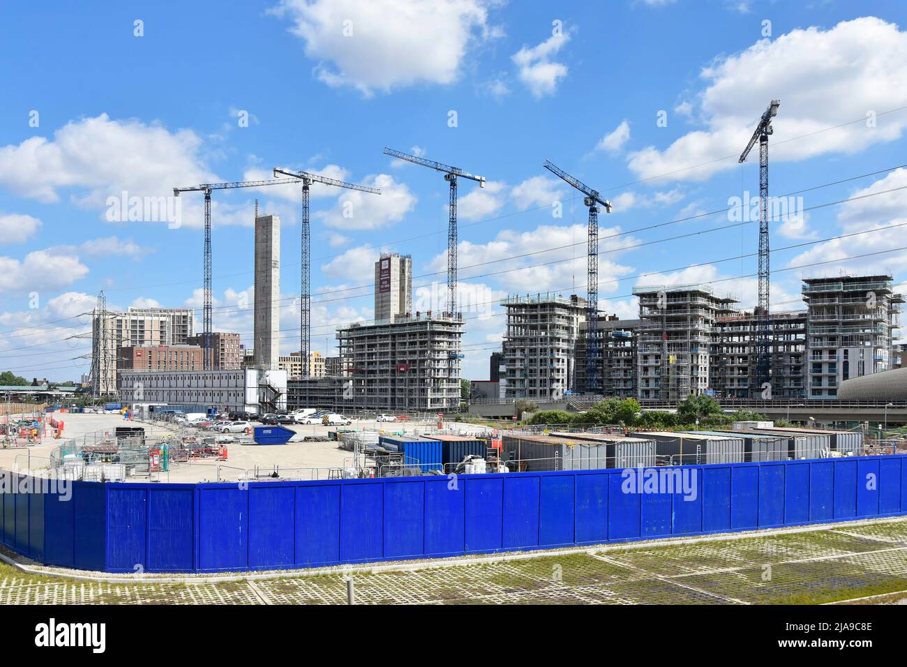 Paneles de madera azul sin marcar que encintan nuevos edificios obra en curso en bloque de apartamentos de gran altura más allá del este de Londres, Reino Unido Foto de stock