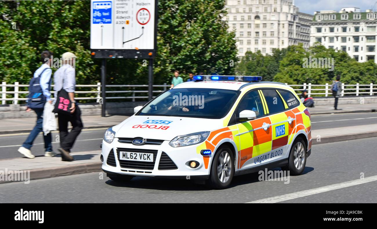 NHS urgente entrega de sangre en un coche Ford blanco con marcas reflectantes Battenberg que conduce en luces azules a velocidad en el puente Waterloo Londres Inglaterra Reino Unido Foto de stock