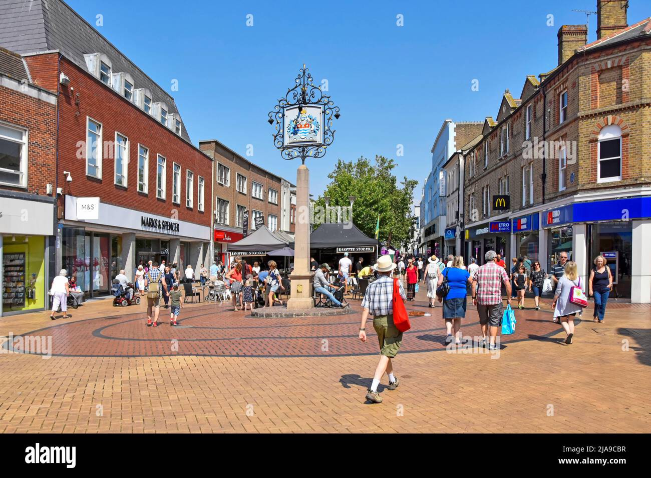 Ciudad de Chelmsford Essex condado de la ciudad con escudo de armas azul cielo día de verano para los compradores de personas en pavimentado ocupado peatonal calle alta Inglaterra Reino Unido Foto de stock