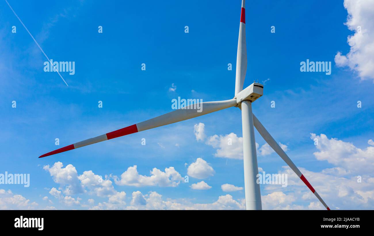 Vista sobre el generador de viento, turbinas, con palas giratorias,  hélices, contra cielo nublado y azul, energía limpia renovable que  convierte energía cinética Fotografía de stock - Alamy